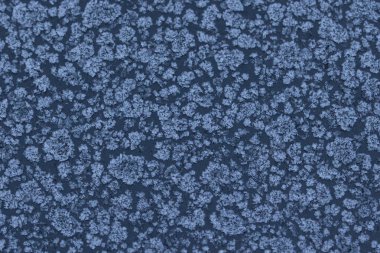 Donmuş bir yüzeyde buz kristali desenleri olan soyut kış soğuğu dokusu. Kar tanesi gibi detaylara sahip doğal buzlu arka plan mevsimlik tasarımlar, soğuk hava konseptleri ve kış tatili temaları için mükemmel..