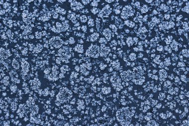 Donmuş bir yüzeyde buz kristali desenleri olan soyut kış soğuğu dokusu. Kar tanesi gibi detaylara sahip doğal buzlu arka plan mevsimlik tasarımlar, soğuk hava konseptleri ve kış tatili temaları için mükemmel..