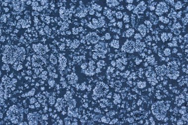 Donmuş bir yüzeyde buz kristali desenleri olan soyut kış soğuğu dokusu. Kar tanesi gibi detaylara sahip doğal buzlu arka plan mevsimlik tasarımlar, soğuk hava konseptleri ve kış tatili temaları için mükemmel..