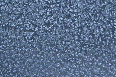 Donmuş bir yüzeyde buz kristali desenleri olan soyut kış soğuğu dokusu. Kar tanesi gibi detaylara sahip doğal buzlu arka plan mevsimlik tasarımlar, soğuk hava konseptleri ve kış tatili temaları için mükemmel..