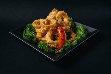 Kıtır kıtır soğan halkaları, marul ve kırmızı biberli.