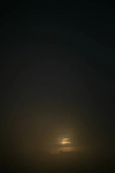 Nascer do sol sobre a cidade em uma manhã nebulosa nublada — Fotografia de Stock
