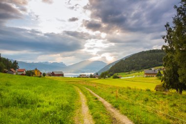 Dağlar ve Norveç fiyortları bakan günbatımı