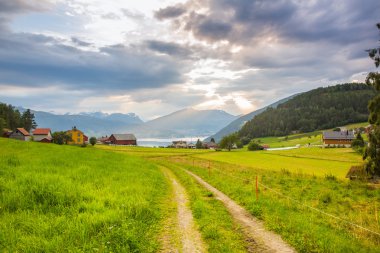 Dağlar ve Norveç fiyortları bakan günbatımı