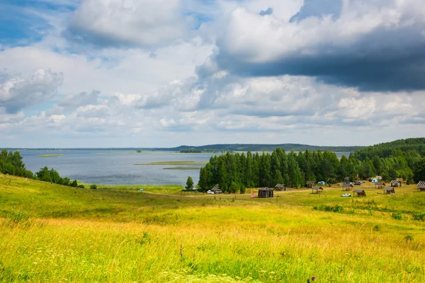 Озеро, лес, поле, большие облака — стоковое фото