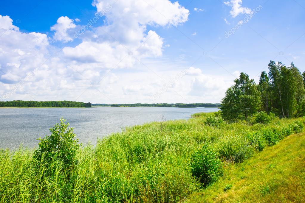 The lake , forest, field , big clouds