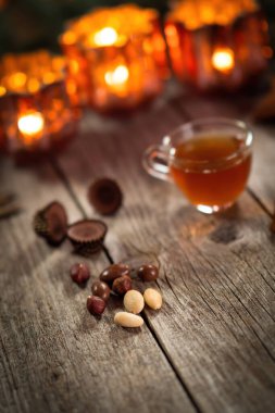 Cevizler, şekerler ve ev yapımı Noel şarabı kokteyli ahşap kırsal masada. Arka planda mum yakmak. Geleneksel sonbahar ve kış ev sahneleri. Yakın plan..