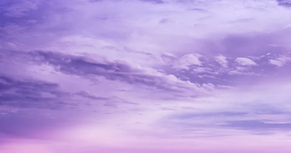 Beautiful purple sky background. Soft white clouds at sunset. Many pink and magenta tones and patterns of clouds.