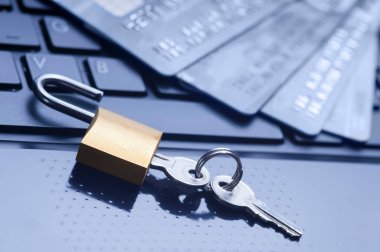 Kilitli kilit, anahtarlar ve mavi bilgisayar klavyesinde dört kredi kartı. E-ticaret verileri ve ebankacılık koruması, İnternet ve finans güvenlik kavramı.