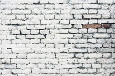 Yaşlanmış beyaz, boyanmış tuğla duvar dokusu. Duvarcılığın eski desenli, grunge duvar yüzey motifi. Çatlaklar ve siyah lekeler.