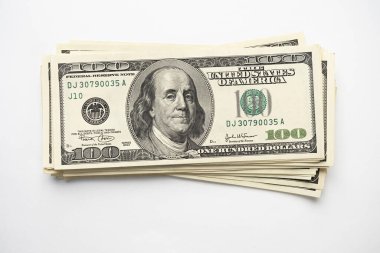 Beyaz arka planda Başkan Franklin 'in portresi olan 100 banknot yığını. Yüz dolarlık banknotlar, kağıt para birimi..