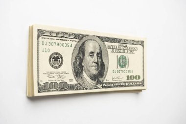 Beyaz arka planda Başkan Franklin 'in portresi olan 100 banknot yığını. Yüz dolarlık banknotlar, kağıt para birimi..