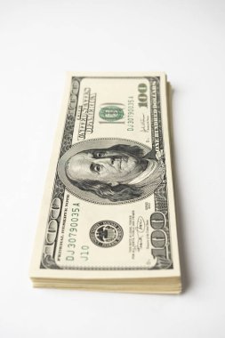 Beyaz arka planda Başkan Franklin 'in portresi olan 100 banknot yığını. Yüz dolarlık banknotlar, kağıt para birimi..