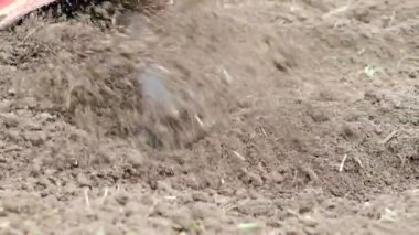 Tiller motoru bahçede çalışıyor. SLOW MOTION HD VIDEO.Cultivator makinesinde. Baharda ekili alanda. Bıçakları yere atmak için çok yakın plan. Modern tarım, teknoloji tarımı. Çeyrek hız.