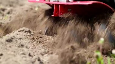 Tiller motoru baharda 4K VIDEO.Cultivator tarlasında çalışıyor. Bıçakları fırlatıp atmak için çok yakın plan. Modern tarım, teknoloji tarımı. Yakın plan..
