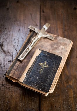 Kırsal ahşap masa üzerinde eski bir kitap üzerinde duran haç ve kutsal İncil. Hıristiyanlık, din, dini sembol. Dua et..