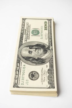 Beyaz arka planda Başkan Franklin 'in portresi olan 100 banknot yığını. Yüz dolarlık banknotlar, kağıt para birimi..