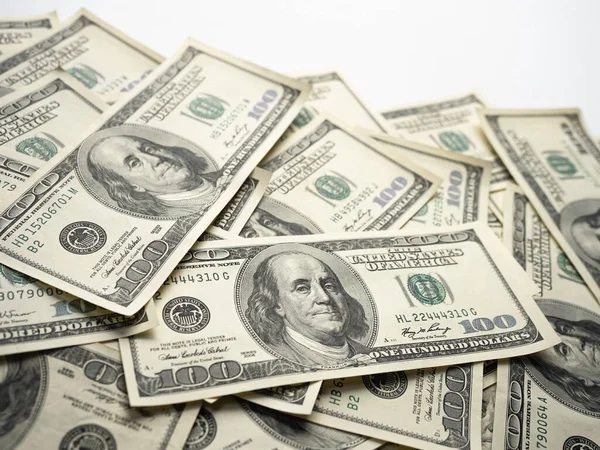 A money pile of one hundred US banknotes with president Franklin portrait on white background. Cash of hundred dollar bills, paper currency background.