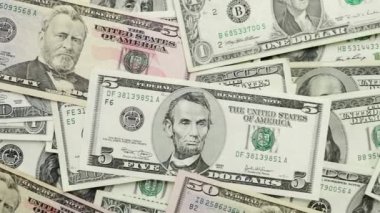4K VIDEO 'da çeşitli Amerikan banknotlarından oluşan bir para yığını. Nakit para, kağıt para geçmişi..