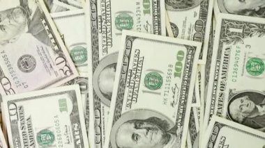 4K VIDEO 'da çeşitli Amerikan banknotlarından oluşan bir para yığını. Nakit para, kağıt para geçmişi..