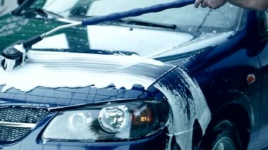 Yavaş Hareket HD video 'da fırça fırçası ve köpük araba yıkama. Beyaz sabunla elle oto yıkama. Etkin şampuan vücuttaki kiri temizler. Araba bakımı. Çeyrek hız.