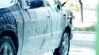 Yavaş Hareket HD video 'da fırça fırçası ve köpük araba yıkama. Beyaz sabunla elle oto yıkama. Etkin şampuan vücuttaki kiri temizler. Araba bakımı. Çeyrek hız.