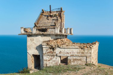 Güneşli bir günde Cape Meganom 'da deniz feneri. Deniz feneri bekçisinin yıkılmış evi..