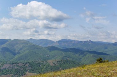 Kırım dağlarının panoramik manzarası, ilkbahar güneşli bir günde doğa. Sudak şehrinin Kırım Yarımadası üzerindeki görüntüsü.