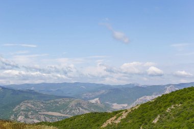Kırım dağlarının panoramik manzarası, ilkbahar güneşli bir günde doğa. Sudak şehrinin Kırım Yarımadası üzerindeki görüntüsü.