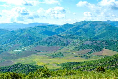 Kırım dağlarının panoramik manzarası, ilkbahar güneşli bir günde doğa. Sudak şehrinin Kırım Yarımadası üzerindeki görüntüsü.