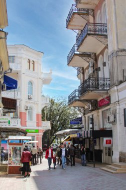 Yalta, Kırım 'ın tarihi bir parçasıdır. Sur boyunca ve merkez caddelerde yürüyen insanlar. Rıhtımda eğlence tekneleri ve yatları.  