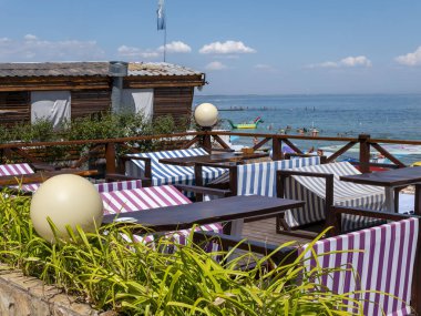 Karadeniz 'deki sahildeki insanlar. Odessa şehir plajlarında dinlenin. Kumsalın ve denizin arka planına karşı plaj kafeleri..