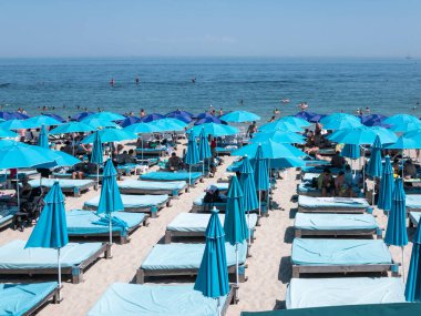 Karadeniz 'deki sahildeki insanlar. Odessa şehir plajlarında dinlenin. Kumsalın ve denizin arka planına karşı plaj kafeleri..