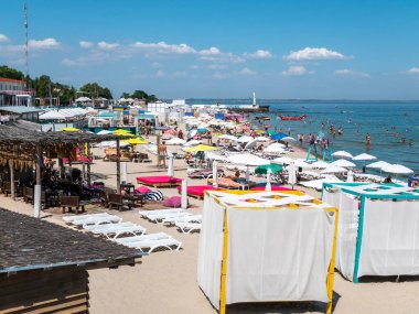 Karadeniz 'deki sahildeki insanlar. Odessa şehir plajlarında dinlenin. Kumsalın ve denizin arka planına karşı plaj kafeleri..