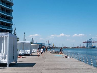 Karadeniz 'deki sahildeki insanlar. Odessa şehir plajlarında dinlenin. Kumsalın ve denizin arka planına karşı plaj kafeleri..