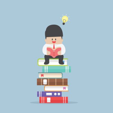 Kitap yığın üzerinde oturan ve okumak işadamı