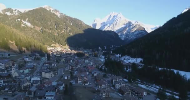 Aéreo acima da aldeia no vento com montanhas vista de neve pico. Drone fly over alpine dolomites snowy Itália Pieve di Cadore — Vídeo de Stock