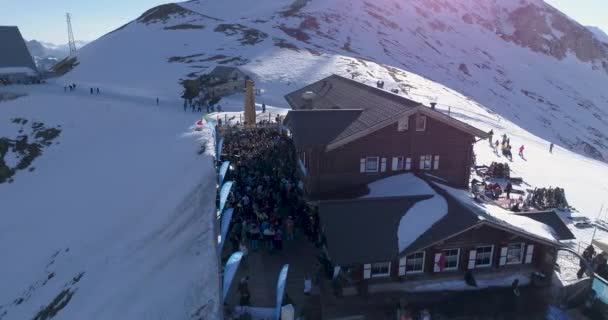 Δολομίτες, Ιταλία - 21 Ιουνίου 2020: Εναέρια πάνω από το χιονοδρομικό κέντρο με κόσμο να διασκεδάζει και να χορεύει στο χιόνι στα χιονοδρομικά κέντρα Δολομίτες — Αρχείο Βίντεο