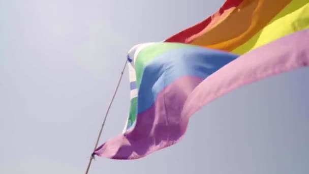Pride Rainbow Flag viftar i vinden med David Shield Israel blå tecken. Låg vinkel skott av hbt färgglada medvetenhet symbol med Magen David flagga med himlen. — Stockvideo
