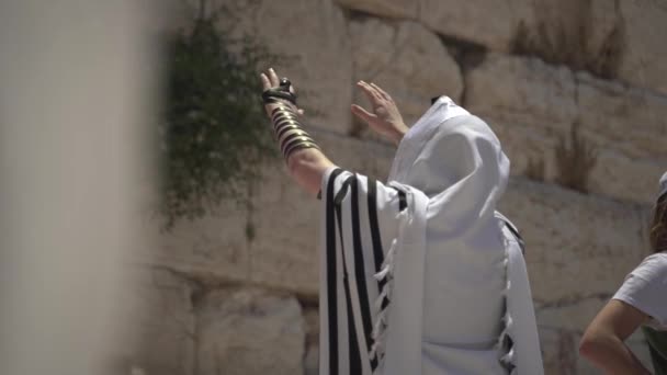 Un judío reza solo en el muro de los lamentos, Cotel. Fortaleza su creencia y fe a Dios vistiendo un talit y tefilín. Acto de espiritualidad en el lugar sagrado sagrado en Jerusalén Israel. — Vídeos de Stock