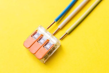 Kablolarla birleştirme aşaması sıfır, zemin sarı arka planda. Elektronik bileşenler. Lehim ya da vidaya ihtiyaç duymadan kabloları bağlamak için kullanılır. Bağlantı konsepti