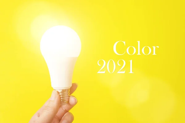 2021年のパントンカラー 手に電球の光 色のトレンド — ストック写真