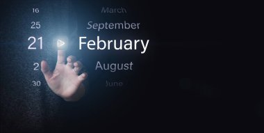 21 Şubat. Ayın 21 'i, takvim tarihi. Koyu mavi arkaplanda el ile aydınlatma simgesi PLAY ve Tarih 'e tıklayın. Kış ayı, yılın günü konsepti.