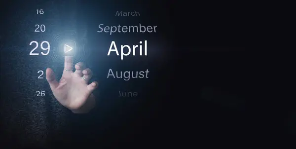 4月29日 月の29日 カレンダーの日付 濃い青の背景にある明るいアイコンの再生と日付を手でクリックします 春の月 その年のコンセプトの日 — ストック写真
