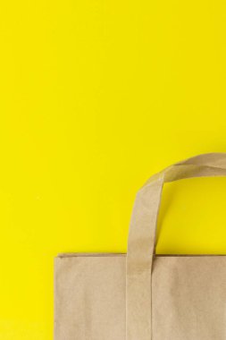 Sarı Arkaplan Üzerinde Kağıt Torba, Kahverengi Alışveriş Çantası. Saplı bir el işi paketi. Paketleme şablonu maketi. Teslimat hizmeti konsepti. Boşluğu kopyala