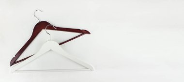 Ahşap elbise askısı beyaz arka planda asılı. Kara Cuma. Bahar sonbahar kıyafeti. Asgari konsept, moda geçmişi