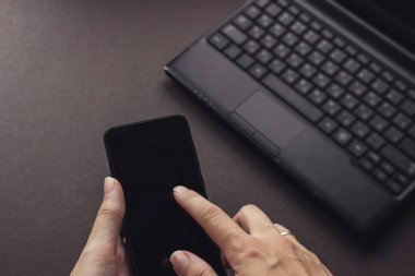 Dizüstü bilgisayarın klavye arka planında telefon var. Dünyayı birbirine bağlayan teknolojiler. Genel ağ.