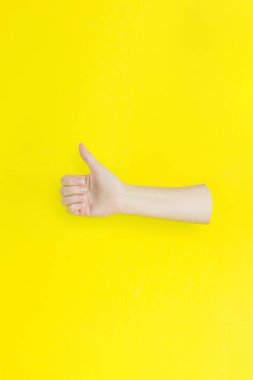 Sarı arkaplan üzerinde başparmak işareti gösteren el kapanışı