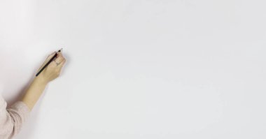 Beyaz arka planda kalem tutan kadın, gri duvara kurşun kalemle yazıyor, boşluğu kopyala