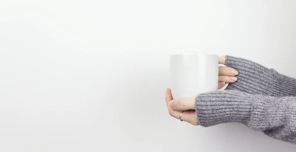 Close-Up Of Hand Holding White Cup Tea Against White Background. Holding a white cup of hot coffee